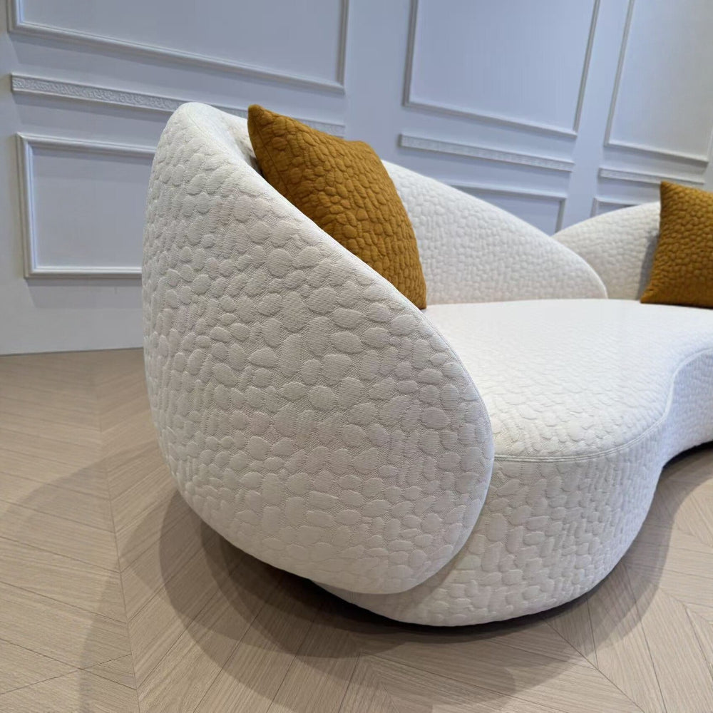 modern boucle curved sofa with textured fabric and orange accent pillows